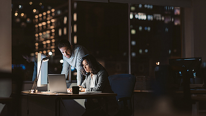 Securepoint Awareness PLUS for more Cybersecurity Man and woman in front of a glowing screen in a dark office