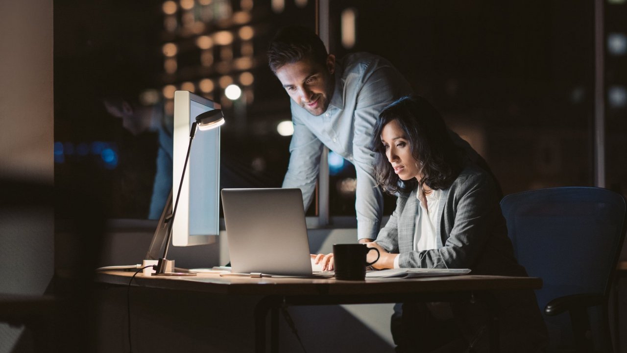 Zwei Personen sitzen abends gemeinsam am Computer