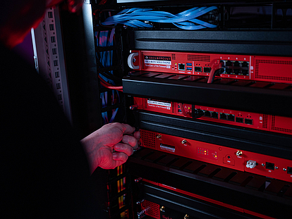 Securepoint UTM-Firewalls lassen sich einfach installieren Ein Techniker schraubt eine Securepoint UTM-Firewall in ein Racksystem