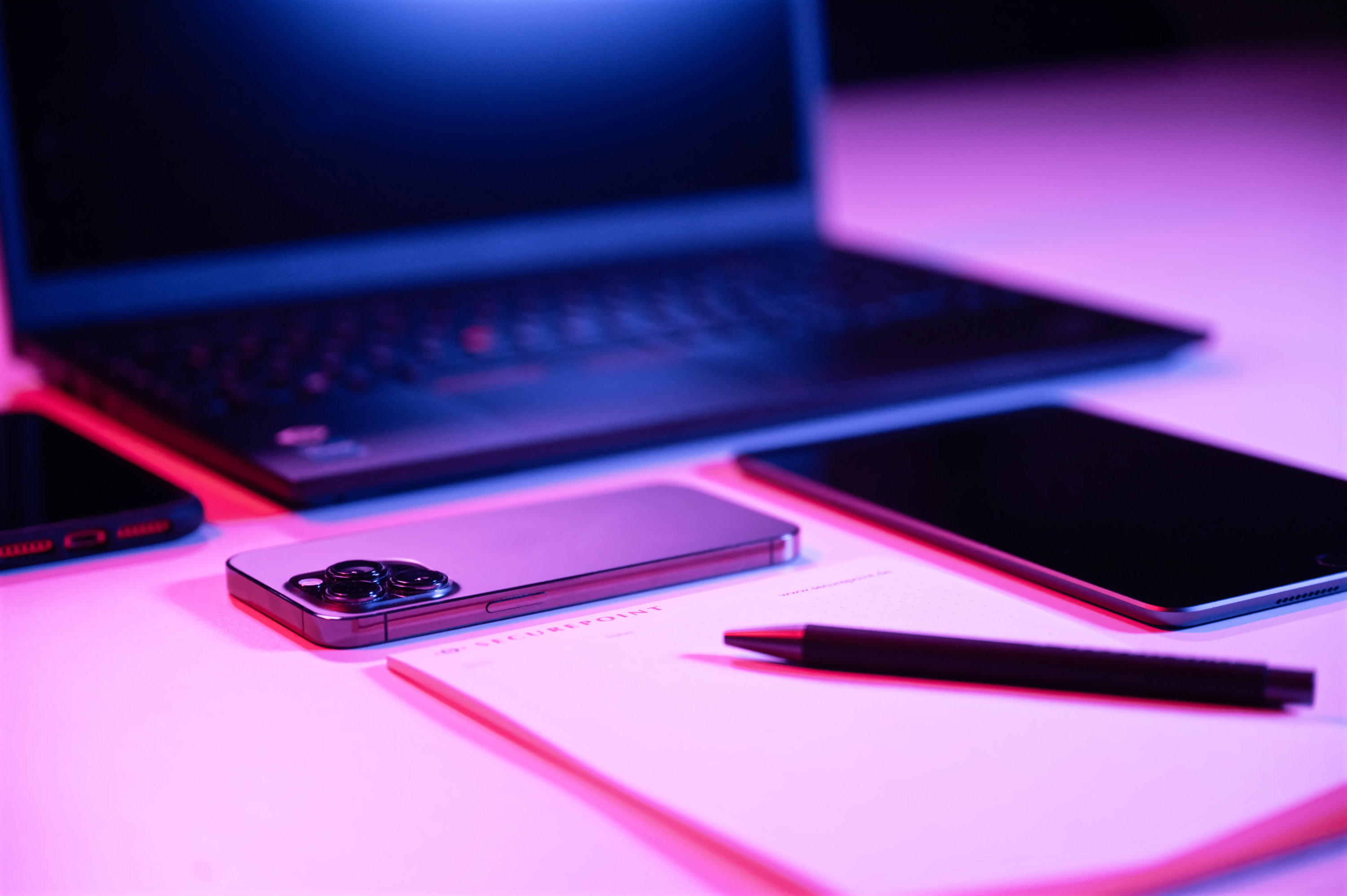 Securepoint Unified Endpoint Protection Laptop, smartphone, notepad and pen on one desk