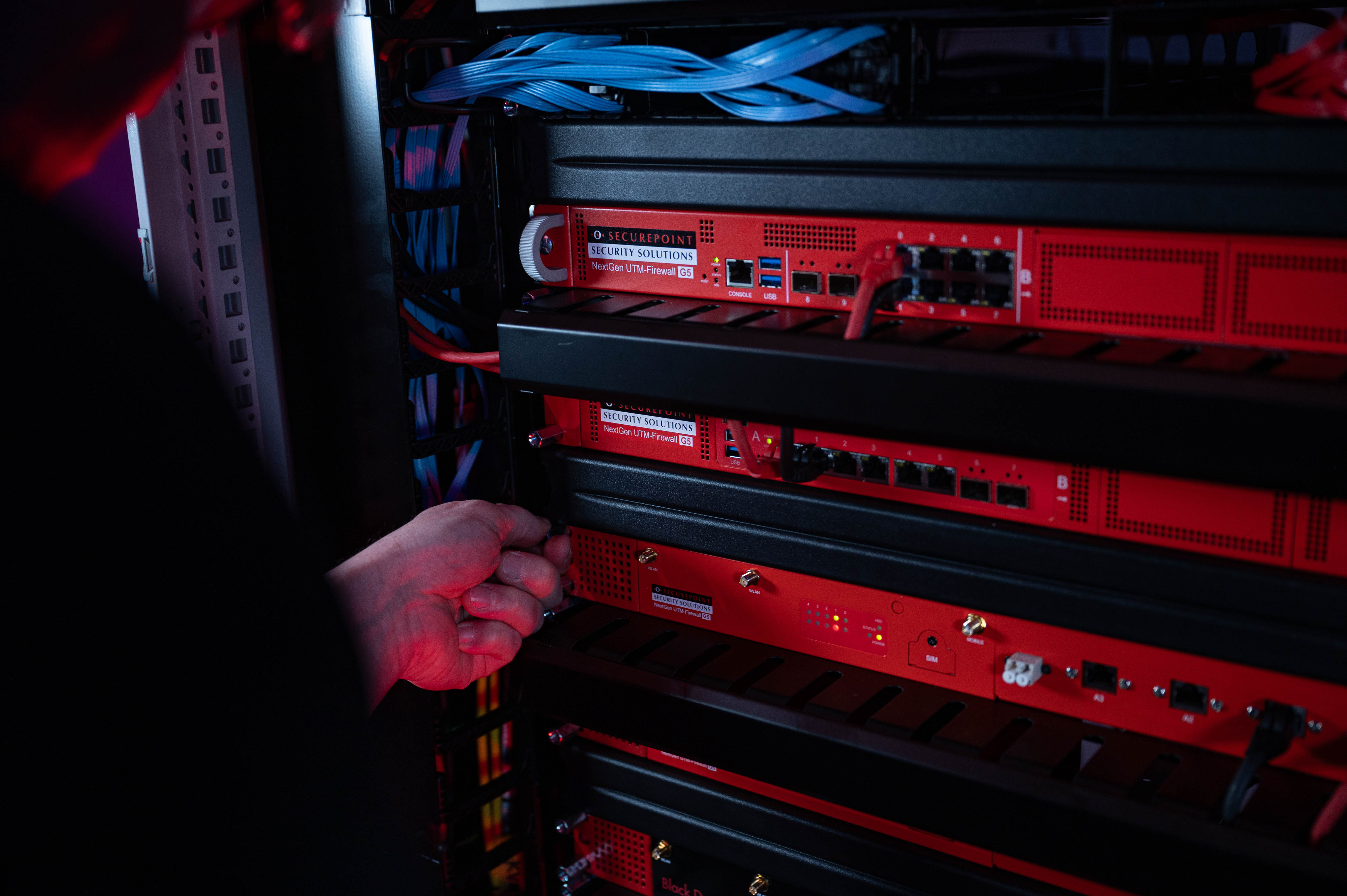 Securepoint UTM-Firewalls lassen sich einfach installieren Ein Techniker schraubt eine Securepoint UTM-Firewall in ein Racksystem