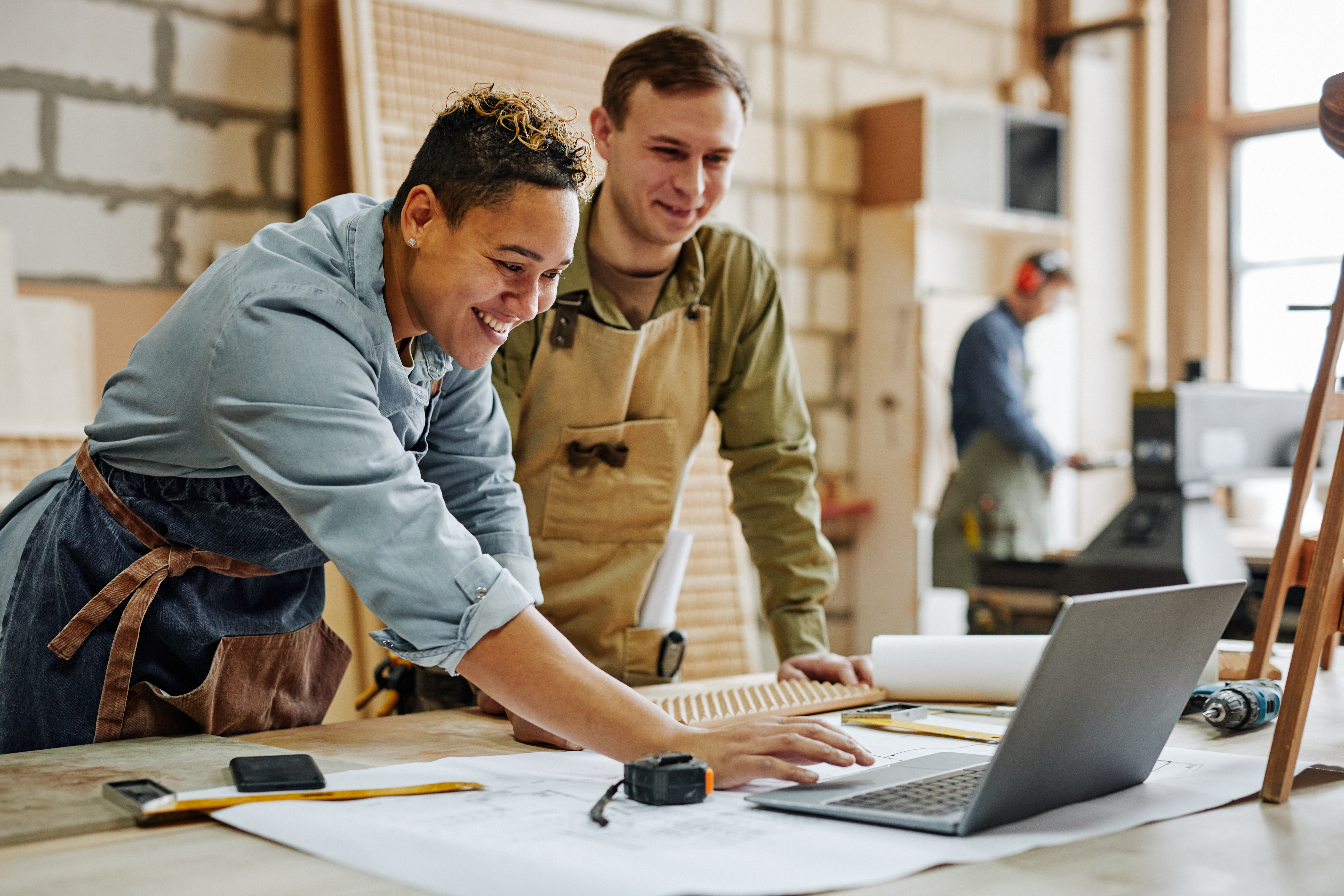 IT security for craft businesses Two craftsmen check plans on a laptop.